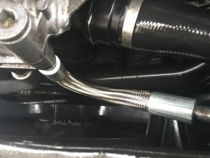 Newly repaired oil line installed on Oil cooler housing on BMW engine.