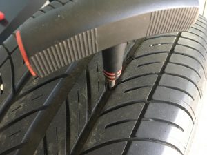 Tire Tool inserted into a cat tire preparing nail hole for tire plug.