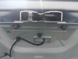 Volvo trunk with lining removed revealing truck latch and trunk latch bolts.