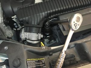 Ratchet with 36mm socket removing engine oil filter housing.