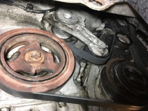 A Ford Escape  New Serpentine Belt positioned on engine pulleys after installation is complete.