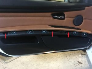 A BMW Coupe Door Panel with door trim removed,  screws and clips are revealed.