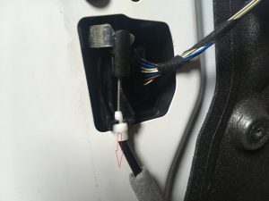 BMW Door Latch Cable mounted on white door frame.