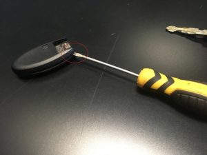  Nissan / Infiniti Key Fob being opened using a screwdriver to replace battery.