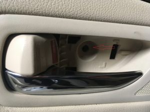 A Beige Lexus Door Handle with door handles screw removed.