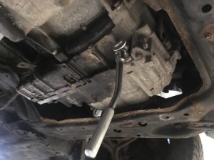 A 3/8 ratchet removing Transmission drain plug on a Honda Accord.