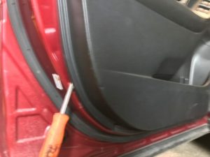 Subaru Forester Door Panel being removed with a flat screwdriver.
